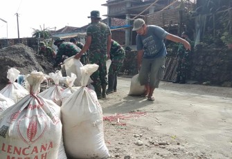 Ketua RW Dusun Ngepoh Bantu TNI Menarik Pasir dengan Karung