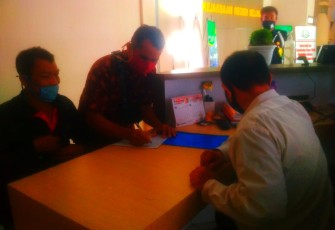 Ketua LSM NCW saat menandatangani surat bukti laporan