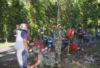 Personil satgas TMMD kodim Bitung saat memberikan pertolongan kepada warga yang mengalami kecelakaan