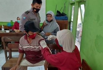 Anggota Polsek Pekalongan Utara meninjau pelaksanaan vaksinasi di Padukuhan kraton Kecamatan Pekalongan Utara , Jum’at, (15/10/2021).