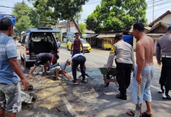 Jajaran Polsek Ngunut Polres Tulungagung melaksanakan kegiatan tanggap keselamatan berlalu lintas dengan melaksanakan penambalan jalan berlubang 