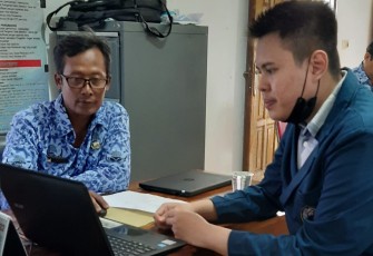Mahasiswa bersama perangkat desa memasukan data hasil rekapitulasi
