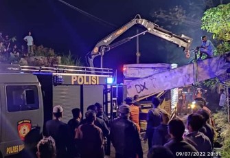 Upaya evakuasi terhadap truk box yang  menabrak dan tertimpa jembatan cor talang air Jalan dr Suharso, Kampung Lingkungan, Kelurahan Jungke, Kabupaten Karanganyar, Sabtu (9/7/2022) malam. (Foto : Istimewa).
