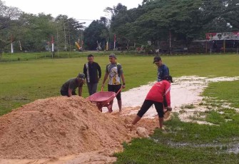 Personil Koramil 04/Sangasanga saat perbaiki lapangan upacara