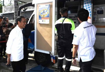 Presiden Joko Widodo saat meninjau bank mobile BUMN di kantor pos kota Baubau, provinsi Sulawesi Tenggara,Selasa (27/9)