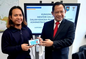 Mendagri Tito Karnavian saat memberikan KTP Digital WNI di Sapporo Jepang, Kamis (29/9)