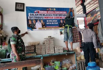 Petugas Satgas Pangan Kota Blitar Saat Membantu Pemasangan Spanduk HET