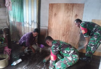Babinsa Koramil Pahandut saat Bantu Warga Bersihkan Lumpur Bekas Banjir 