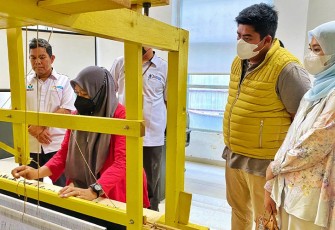 Bupati Bintan bersama ketua Dekranasda Bintan Hafizha saat memperhatikann cara bertenun