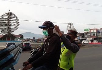 Petugas Sat Lantas Polres Kepahiang saat kenakan langsung masker ke salah seorang pengendara.