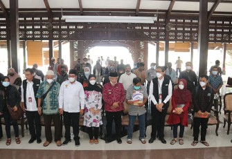 Direktur Utama Bank Jatim, Busrul Iman (kiri) menyerahkan santunan duka kepada keluarga korban Stadion Kanjuruhan, di Pendopo Kabupaten Malang, Kamis (6/10/2022).