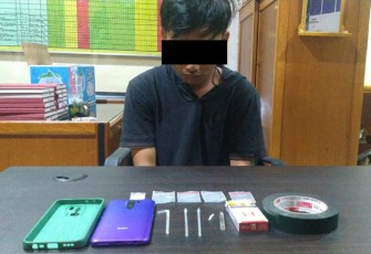 Tersangka saat diamankan beserta barang bukti