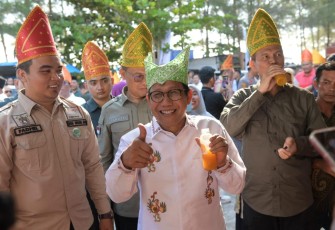 Mendes PDTT Abdul Halim Iskandar saat menikmati produk olahan BUMdes di Pantai Desa Apar Kota Pariaman, Jum'at (11/8)