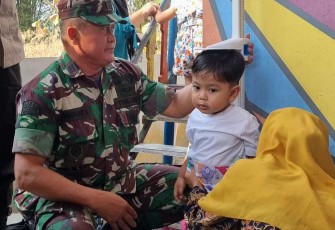 Danramil 16/Wonosari Kapten Inf Suwandi ketika mengukur tinggi anak di posyandu Desa Sidomulyo, Rabu (23/8)