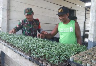 Babinsa Koramil 1710-07/Mapurujaya saat Bantu Petani Binaan Menyemai Bibit Cabe