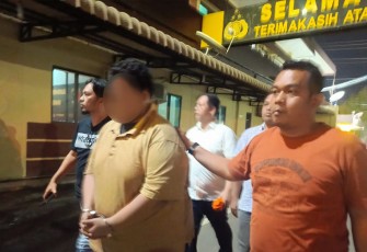 Polisi saat menangkap tersangka (diborgol)