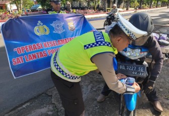 Polantas saat pasang stiker himbauan keselamatan berlalu lintas