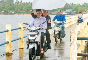 Dengan menggunakan sepeda motor...Ansar tersenyum ke masyrakat pulau Karas 