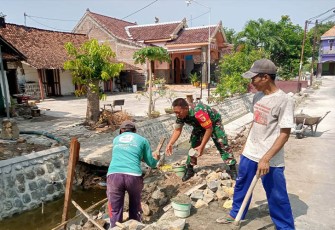Babinsa Serda Suwarni saat Bantu Masyarakat Bangun Talud