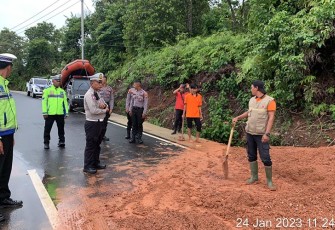 Polisi bersama Damkar dan BPBD Benteng Lakukan Pembersihan Badan Jalan Terkena Material Tanah Longsor.