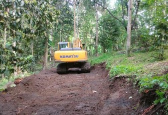 Alat berat yang di gunakan oleh satgas TMMD Ke-116 Kodim 1310/Bitung terus bergerak melakukan pembongkaran jalan
