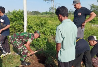 Babinsa di Koramil 14/Dagangan, Kodim 0803/Madiun bersama warga bergotong-royong menanam pohon di sepanjang jalan yang ada di Dusun Sawahan, Desa Dagangan, Kecamatan Dagangan, Kabupaten Madiun