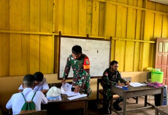 Babinsa Koramil 1710-06/Agimuga Serda Margo Triyanto membantu proses belajar mengajar kepada siswa-siswi SMP Negeri Agimuga di Kampung Kiliarma, Distrik Agimuga, Kab. Mimika, Senin (3/6/2024)