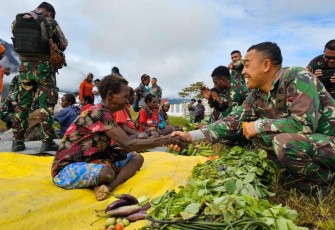 Anggota Satgas 330 Tri Dharma saat borong dagangan masyarakat Intan Jaya