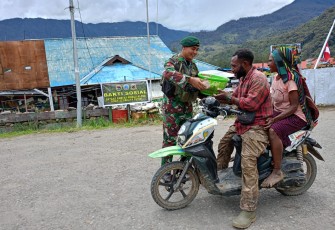 Prajurit Satgas Pamtas RI-PNG Mobile Yonif 323/BP Kostrad Pos Kout Ilaga Menyalurkan Cinta Kasih nya di kegiatan Minggu Kasih dengan membagikan Nasi Bungkus Kepada Masyarakat yang lewat Depan Pos, Distrik Ilaga, Kab.Puncak, Minggu (10/03/2024)