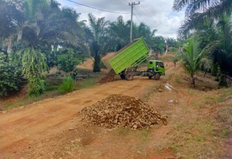 Dump Truck Tumpahkan Material Batu Pecah untuk Pengerasan Jalan dalam Kegiatan TMMD Ke-119