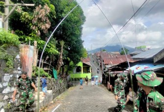Dan SSK TMMD Ke-123 Kodim 1310Bitung, Lettu Czi Hendri Satria bersama warga dan personil satgas lainnya saat melaksanakan karya bakti pemasangan lampu hias jalan di kelurahan Wangurer Barat