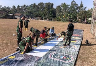 Pemasangan banner penutupan TMMD