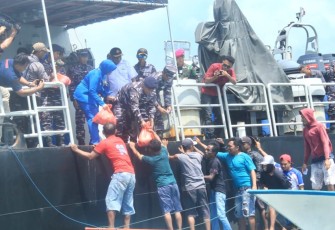 TNI AL mendistribusikan bantuan paket sembako kepada puluhan nelayan yang mendekati KRI Dorang-874 saat melaksanakan lego jangkar di perairan belakang Pulau Wamar, Kepulauan Aru