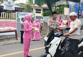 Kapolsek Ranowulu, Iptu Teguh Pambudi didampingi istri tercinta saat membagikan takjil gratis kepada pengendara motor