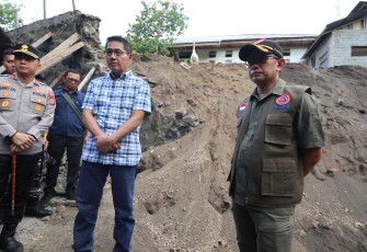 Kepala Pusat Data Informasi dan Komunikasi Kebencanaan (Kapusdatinkom) BNPB, Abdul Muhari (kanan) bersama Wali Kota Bitung, Hengky Honandar (baju kotak-kotak) saat meninjau talud yang rusak mengenai rumah warga setelah diguncang gempabumi M 7,6 di Kelurahan Manembo-Nembo Tengah, Kecamatan Matuari, Kota Bitung, Sulawesi Utara, Jumat (3/4)